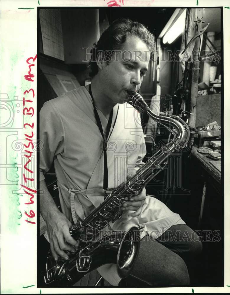 1988 Jonathan Smith tests a tenor sax after overhauling instrument - Historic Images