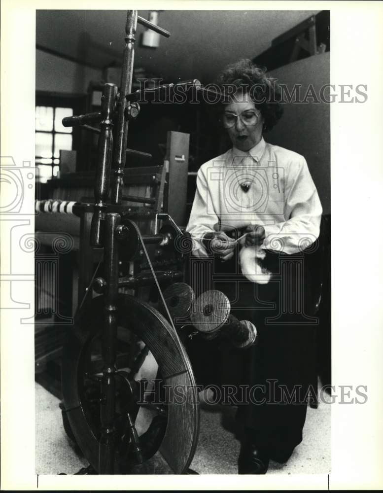 1992 Aggie Hurdle uses wooden spinning wheel to spin yarn - Historic Images