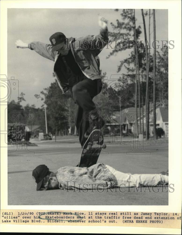 1990 Press Photo Mark Rice stays still as Jamey Taylor ollies over on skateboard - Historic Images