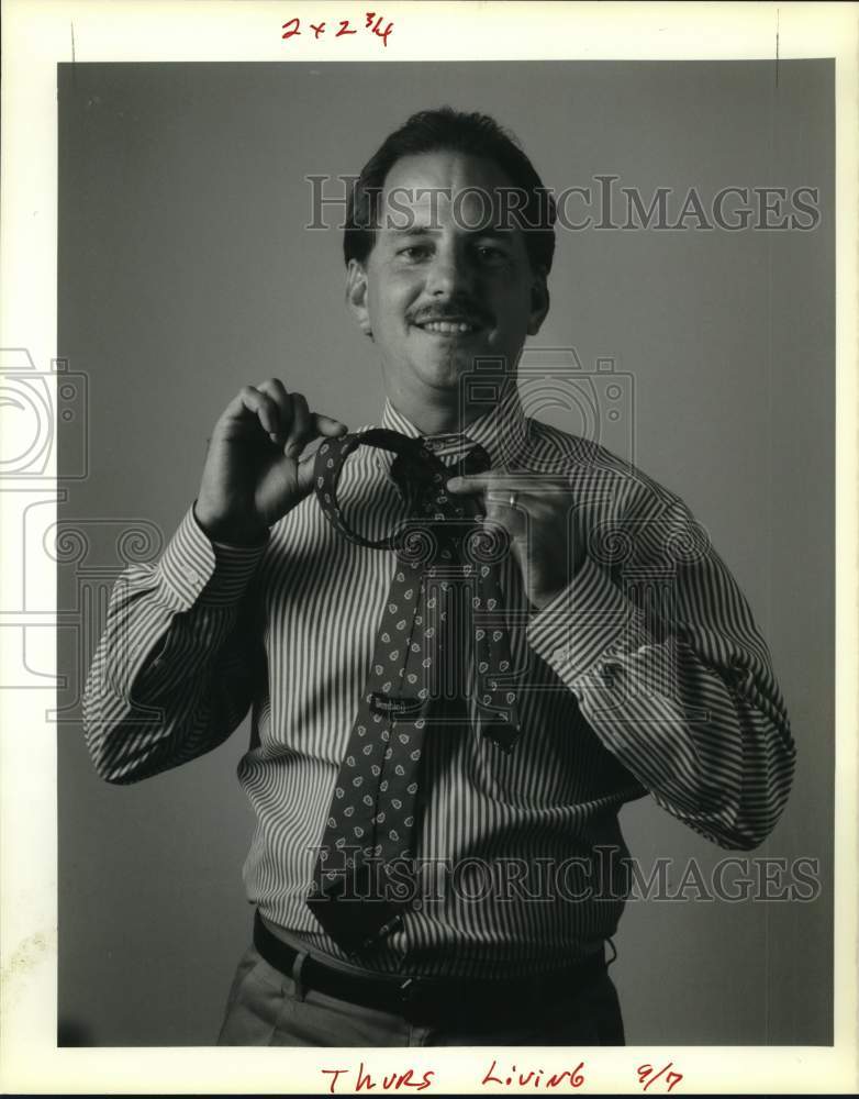 1989 Rick Vogler of Wimbley demonstrates how to tie a tie. - Historic Images