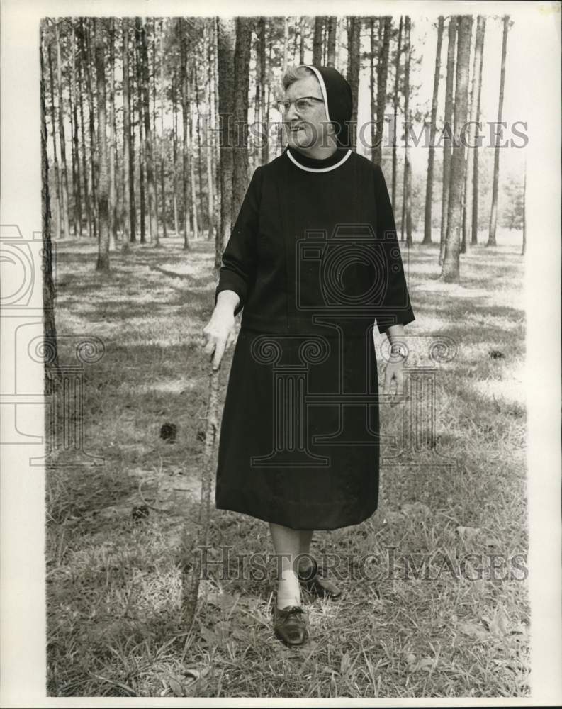 1969 Sister Margaret Donahue walks in wooded area. - Historic Images