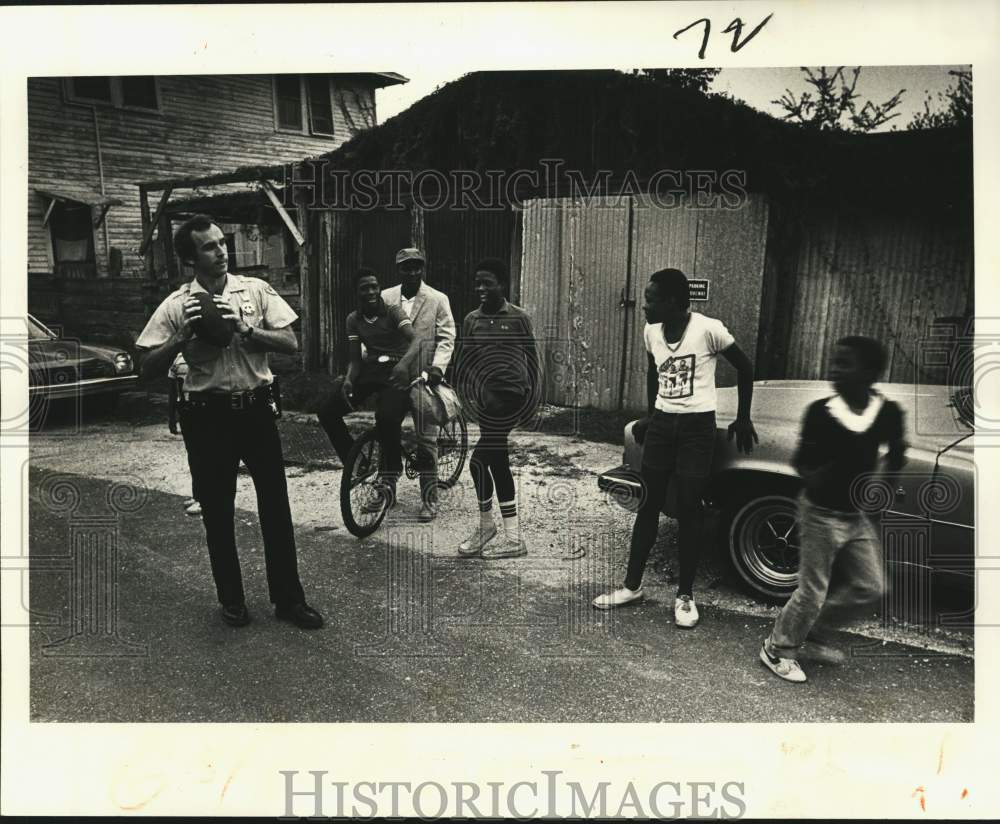 1982 Press Photo New Orleans patrolman Dave Trahan throws a football pass - Historic Images