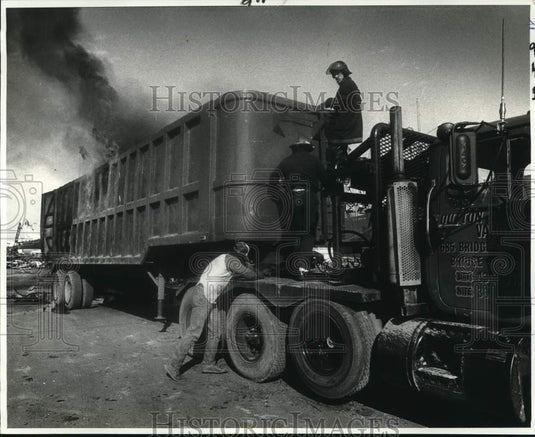 1982 Press Photo Fireman Chris Mickal fights blaze on Oswald White's truck- Historic Images