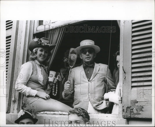 1967 people in costumes perched on window during Mardi Gras - Historic Images