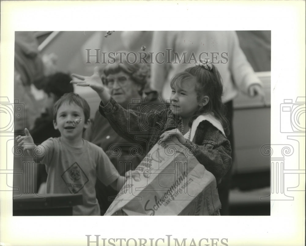 1990 Dan and Kelle Serio reach for bubblegum at Driftwood Parade - Historic Images