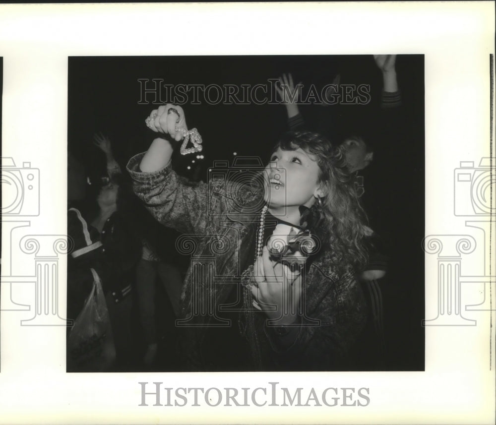 1990 Tracy Rome catches beads during the Crew of Saturn parade - Historic Images