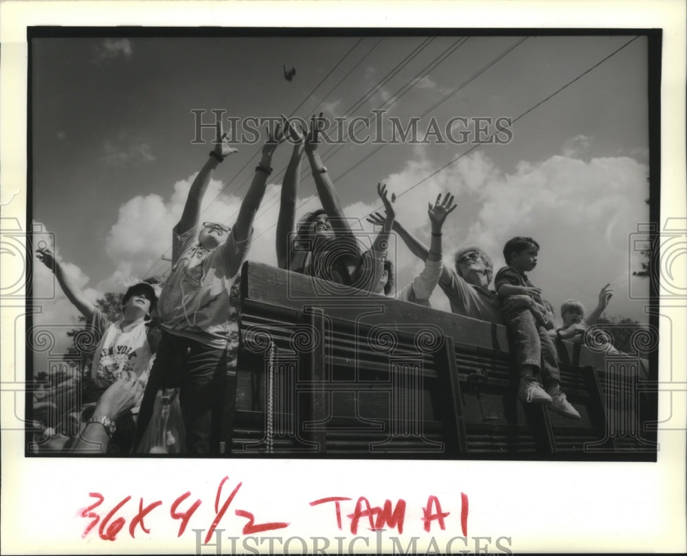 1990 people reach for beads during Covington Lions parade - Historic Images