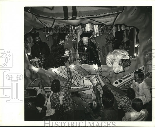 1986 people reach at Mardi Gras parade float for beads  - Historic Images