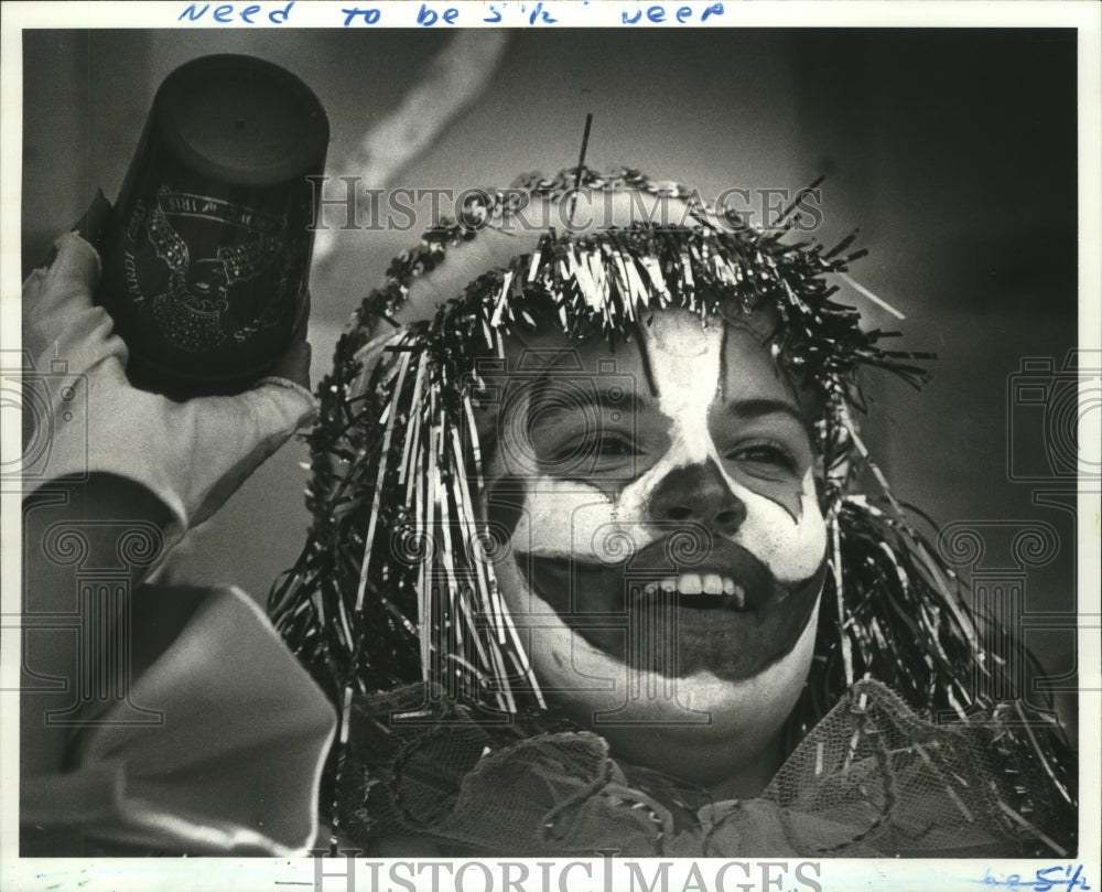 1987 Mardi Gras Iris parade clown gets ready to throw an Iris Cup. - Historic Images