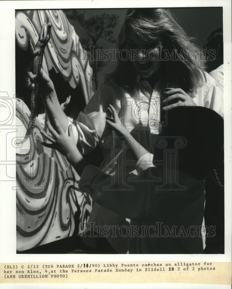 1990 Carnival spectator Libby Puente catches an alligator for son. - Historic Images