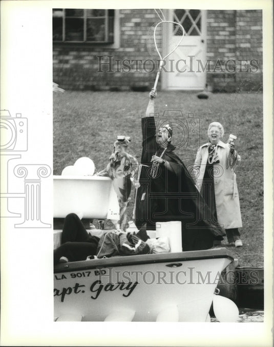 1990 Carnival reveler nets beads as a boat passes Saturday. - Historic Images