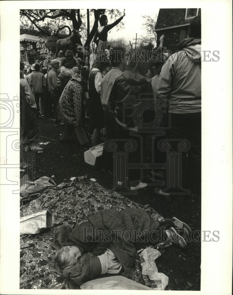 1986 Child Sleeping as Crowd Watches Carnival in New Orleans - Historic Images