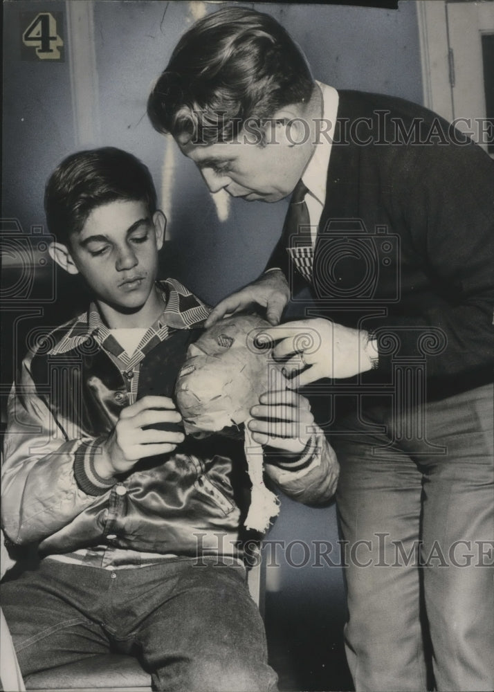 Carnival Mask being examined by man and boy  - Historic Images