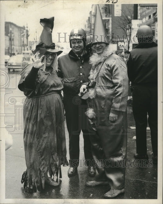 1972 Carnival maskers pose for photographer on the street. - Historic Images
