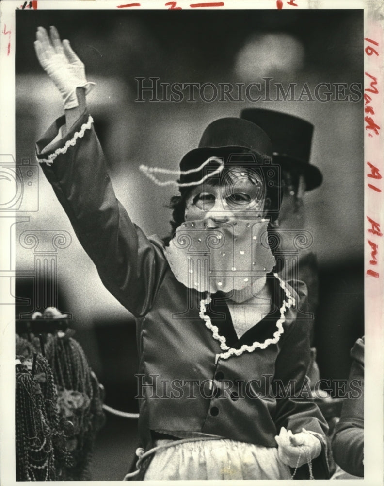 1983 Member of all female Krewe of Iris lets loose with some beads - Historic Images