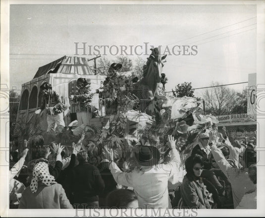 1969 Mardi Gras parade float riders toss beads and favors to crowds - Historic Images