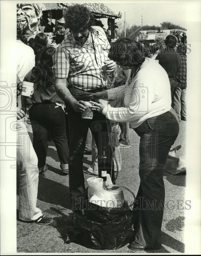 1980 Carnival Maskers Masker gets refill on drink at Arabi parade. - Historic Images