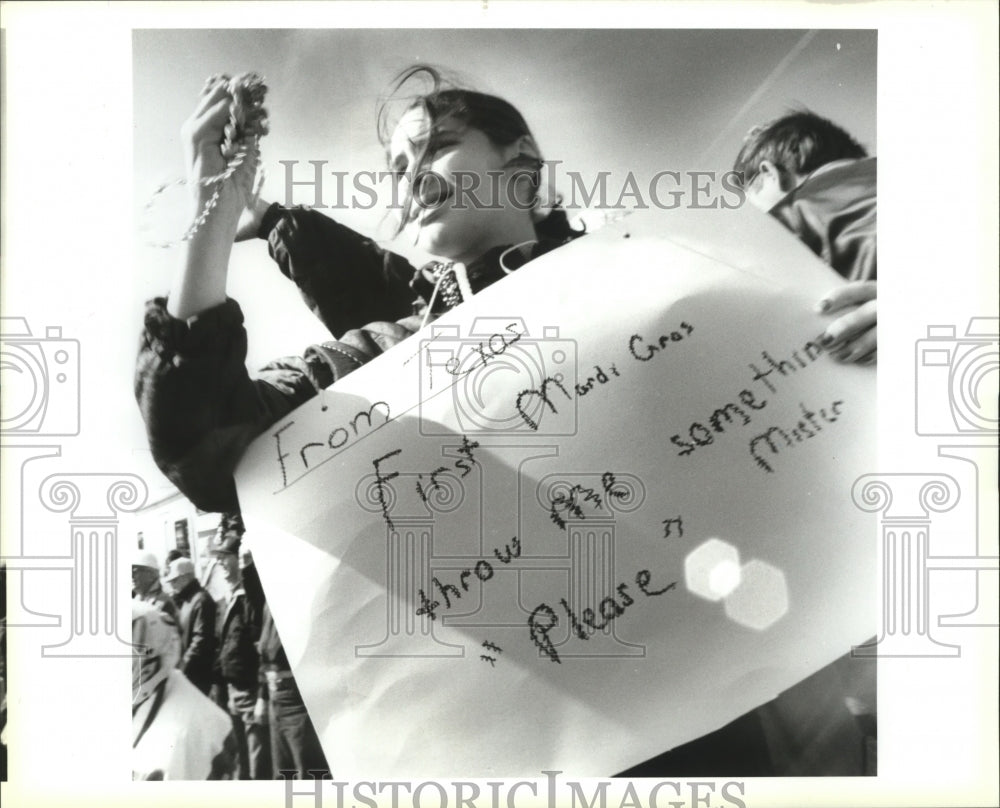 1994 Carnival Parade Lindsay Michel.,11, catches beads holding sign. - Historic Images