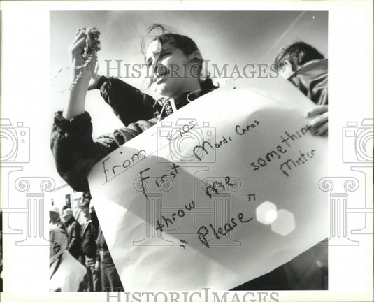 1994 Carnival Parade Lindsay Michel.,11, catches beads holding sign. - Historic Images