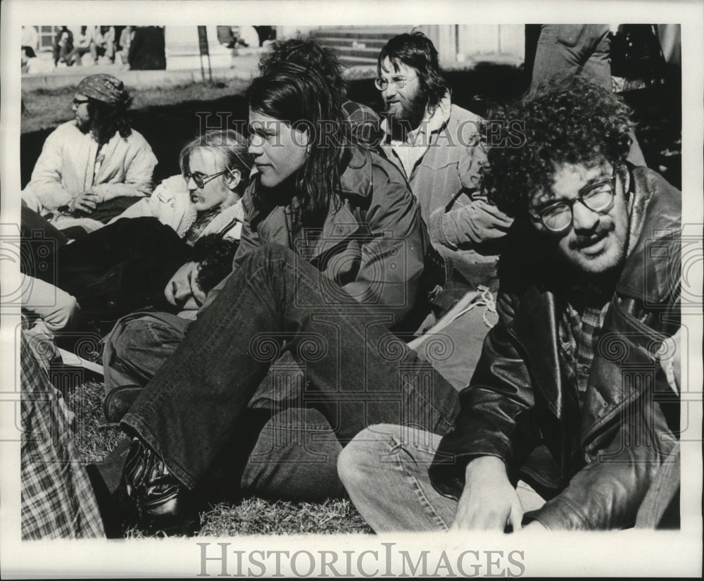 1974 Carnival Visitors. Visitors get comfortable waiting for parade - Historic Images