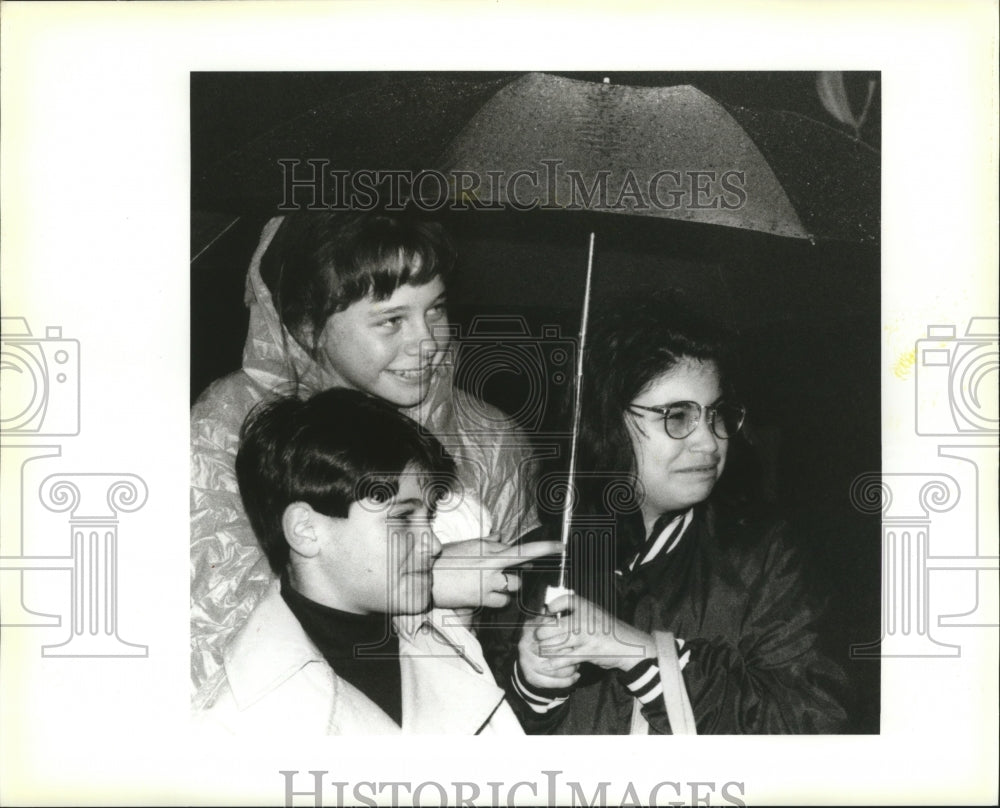 1995 Philip, Julie, and Rebecca Stand Under Umbrella at Juno Parade - Historic Images