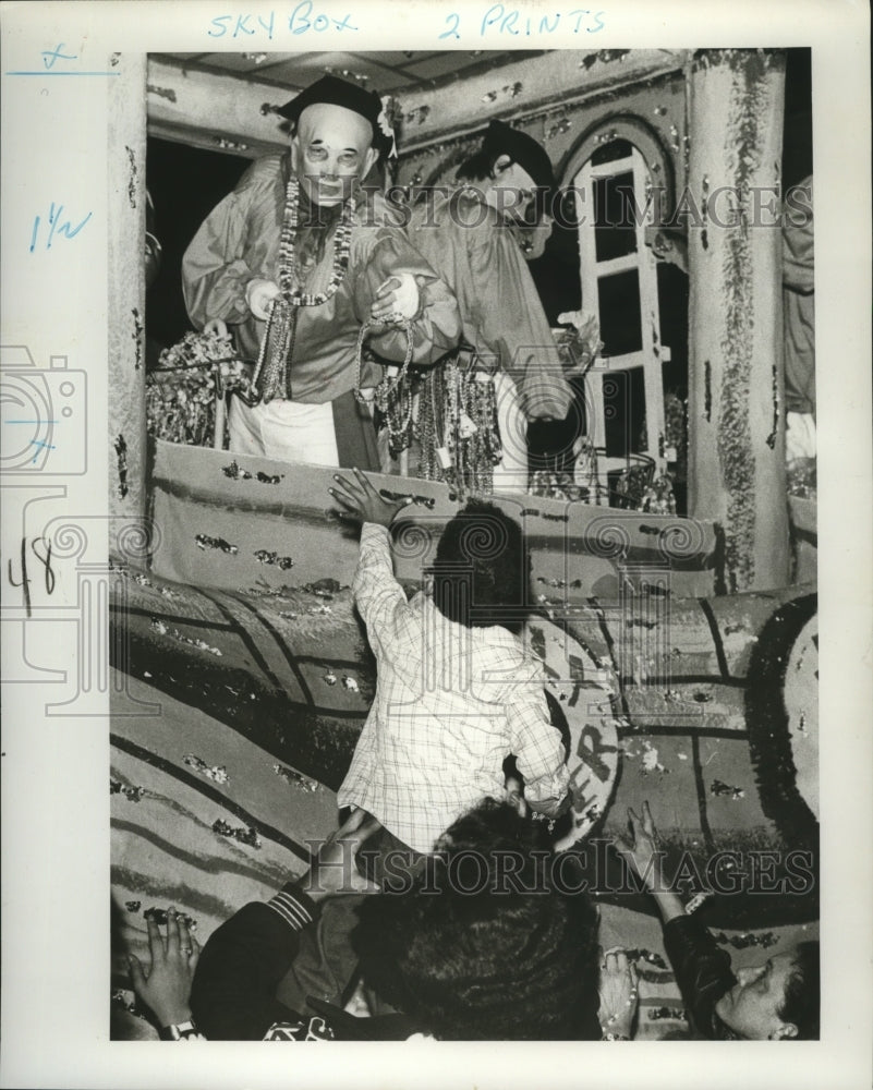 1977 Masker Hands Beads to Spectator in Krewe of Hermes Parade - Historic Images