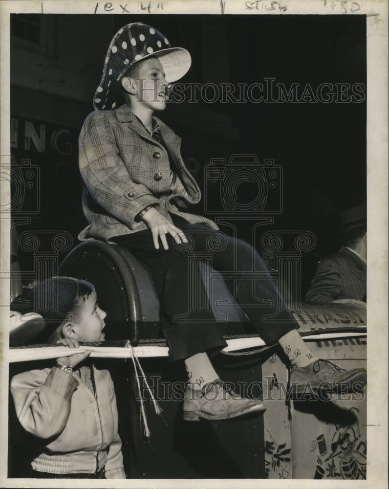 1959 Spectator Sitting on Trash Can at Momus Carnival Parade - Historic Images