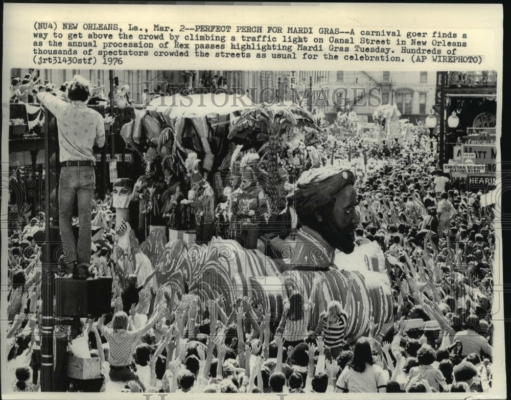 1976 Carnival Parade goer gets above the crowd on a traffic light - Historic Images