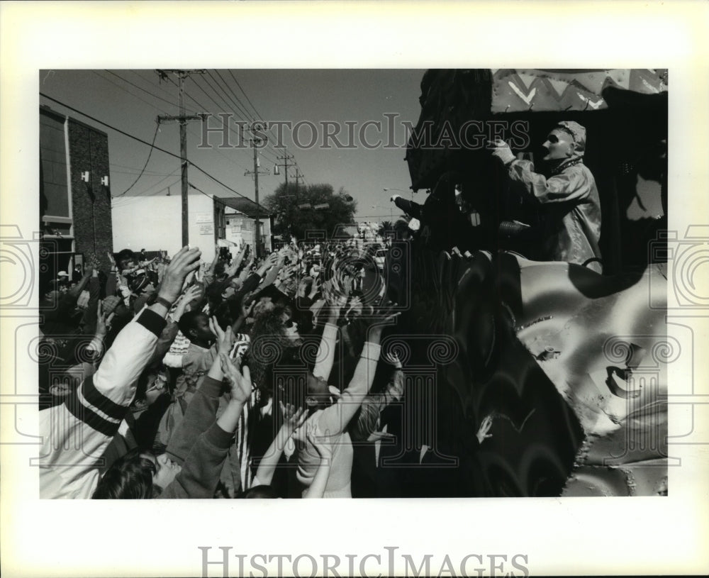 1993 Arms raise for throws from the Krewe of Pontchartrain Parade - Historic Images