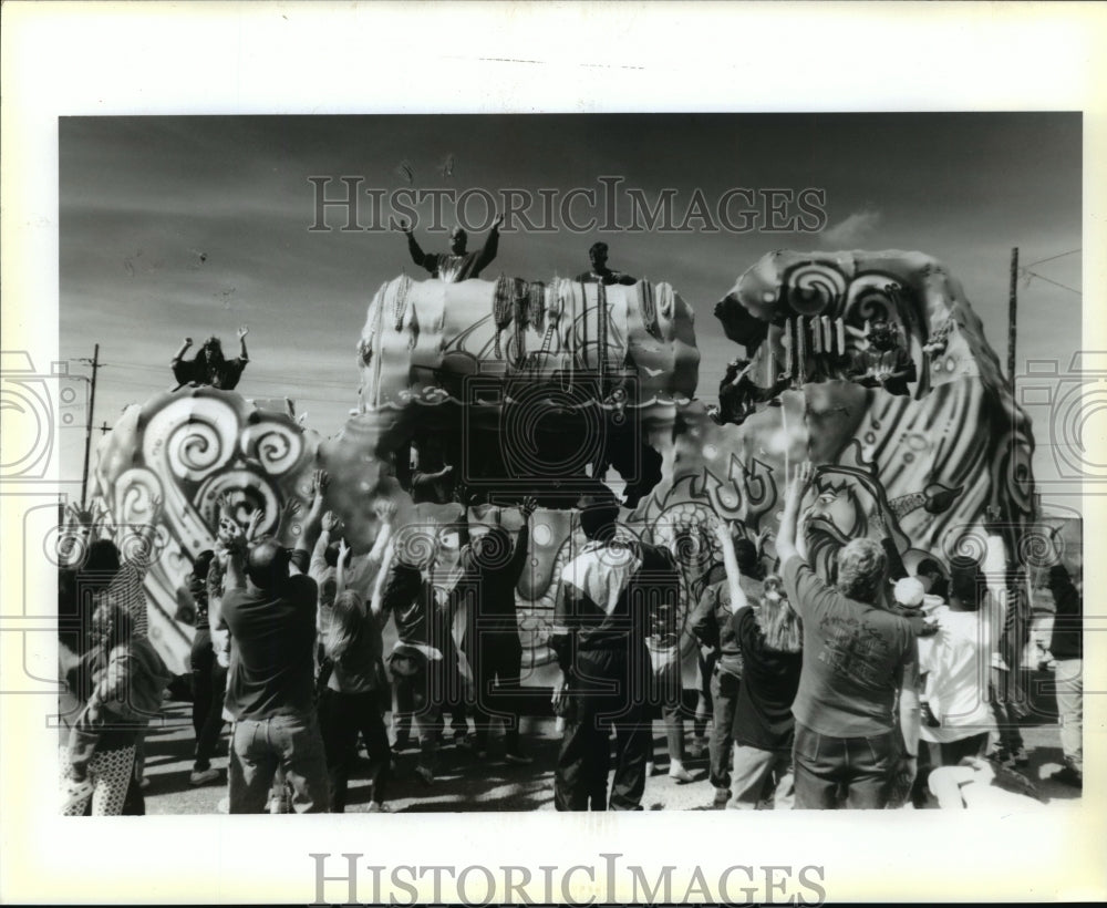 1995 Members of the Krewe of Poseidon give parade goers beads - Historic Images