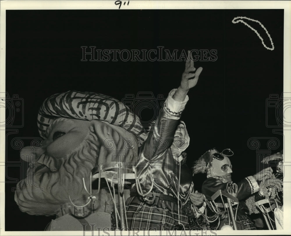 1984 Krewe of Pegasus Mardi Gras Parade riders throw beads to crowds - Historic Images