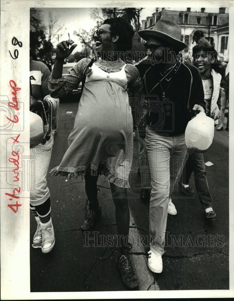 1968 Carnival Parade Couple second lining behind one of the bands. - Historic Images