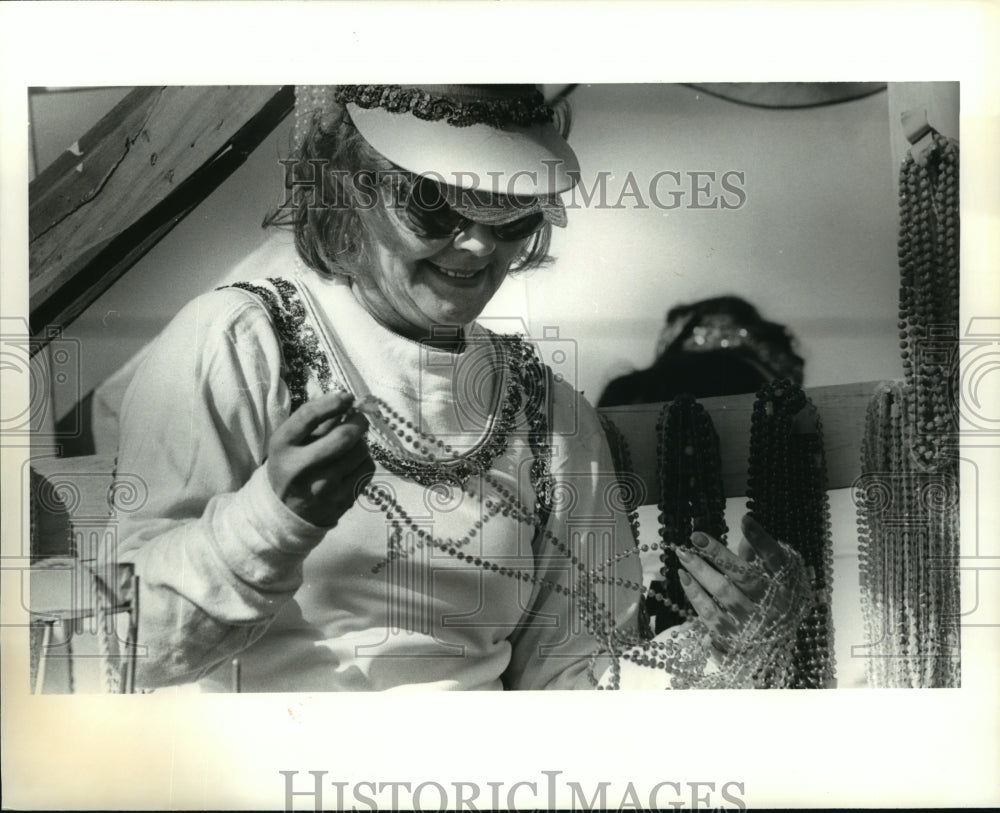 1979 Rider on a Rhea parade float on Mardi Gras holds beads to throw - Historic Images