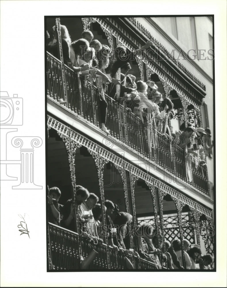 1992 Carnival Revelers Hang from Bourbon St. Balcony Tossing Beads - Historic Images