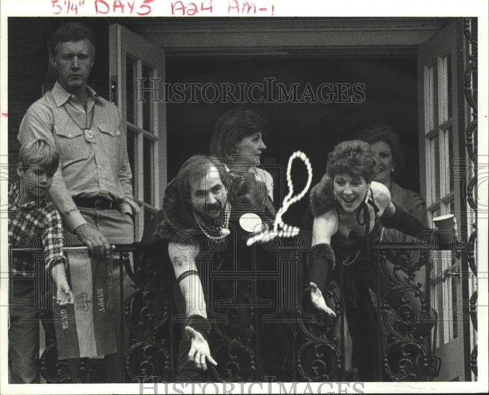 1985 Couple Makes Effort to Catch Beads From Balcony at Mardi Gras - Historic Images