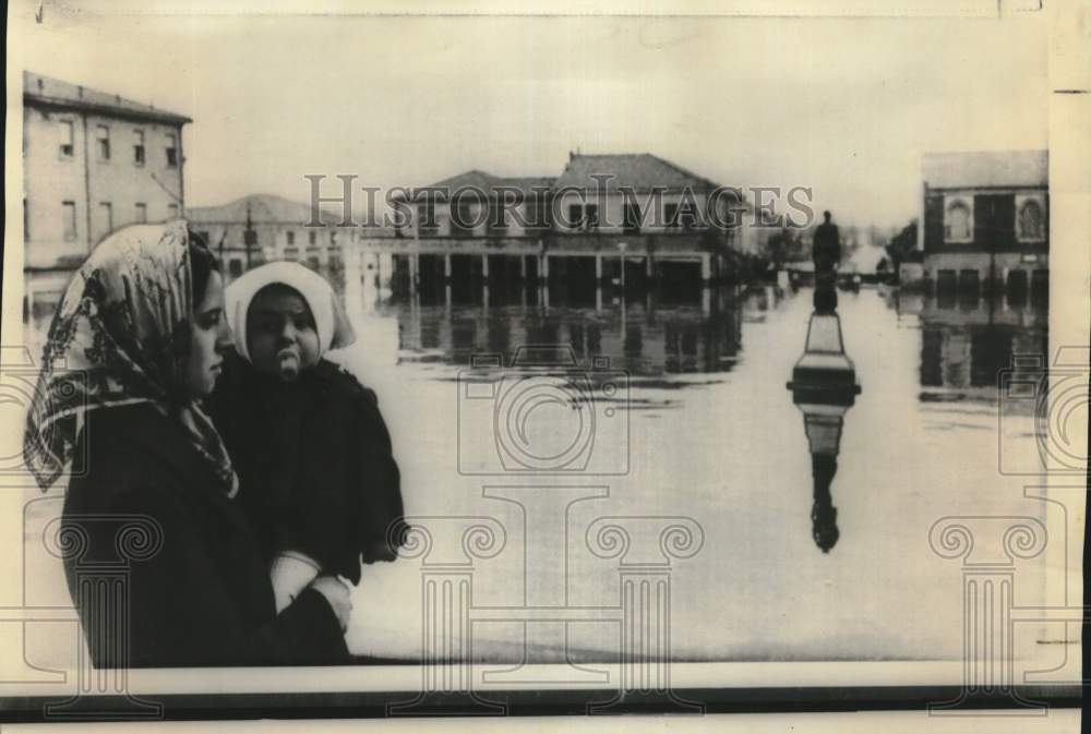 1966 Press Photo A woman holds child as she views the flood waters in Italy - Historic Images