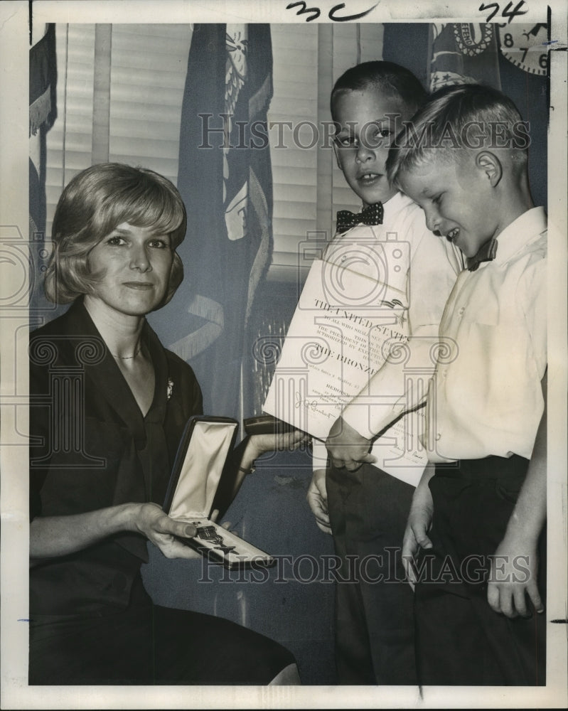 1965 Mrs. Rubin Bradley holds Infantry Badge for slain husband - Historic Images