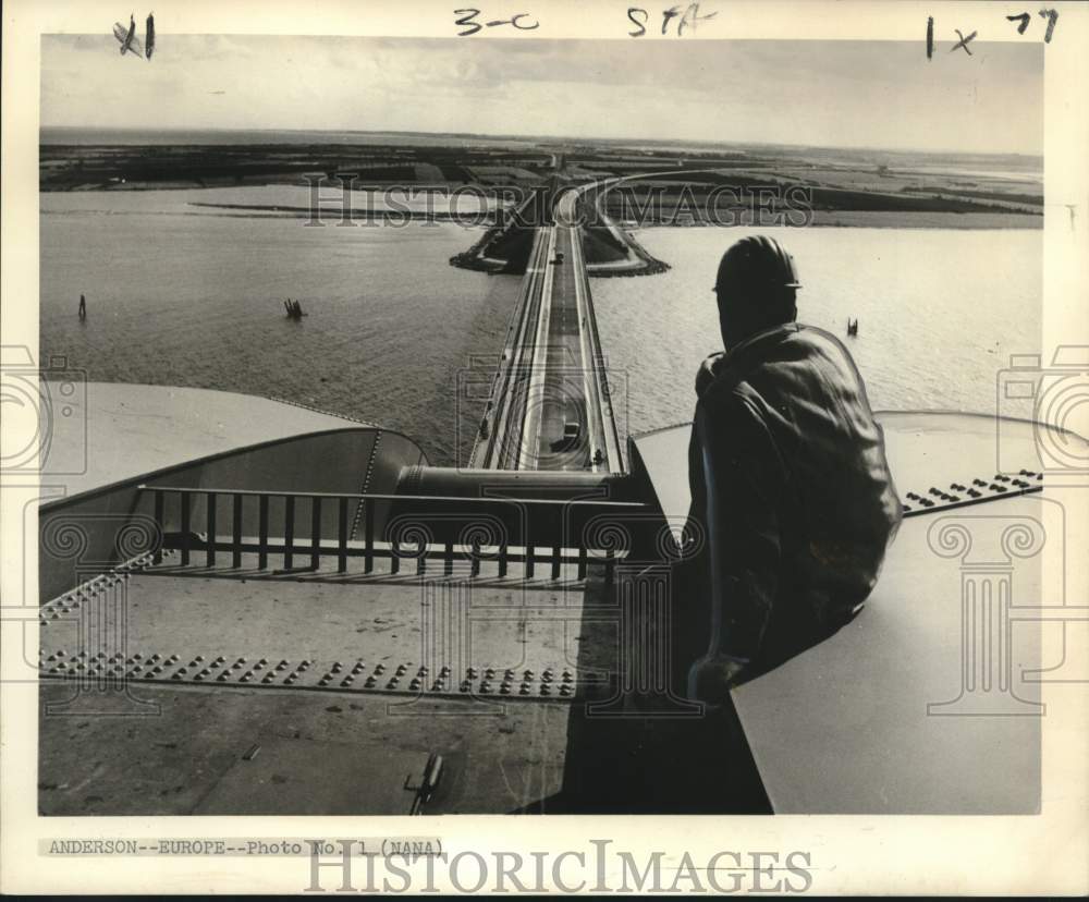 1964 Workman looks out across Fehmarn Bridge, West Germany - Historic Images