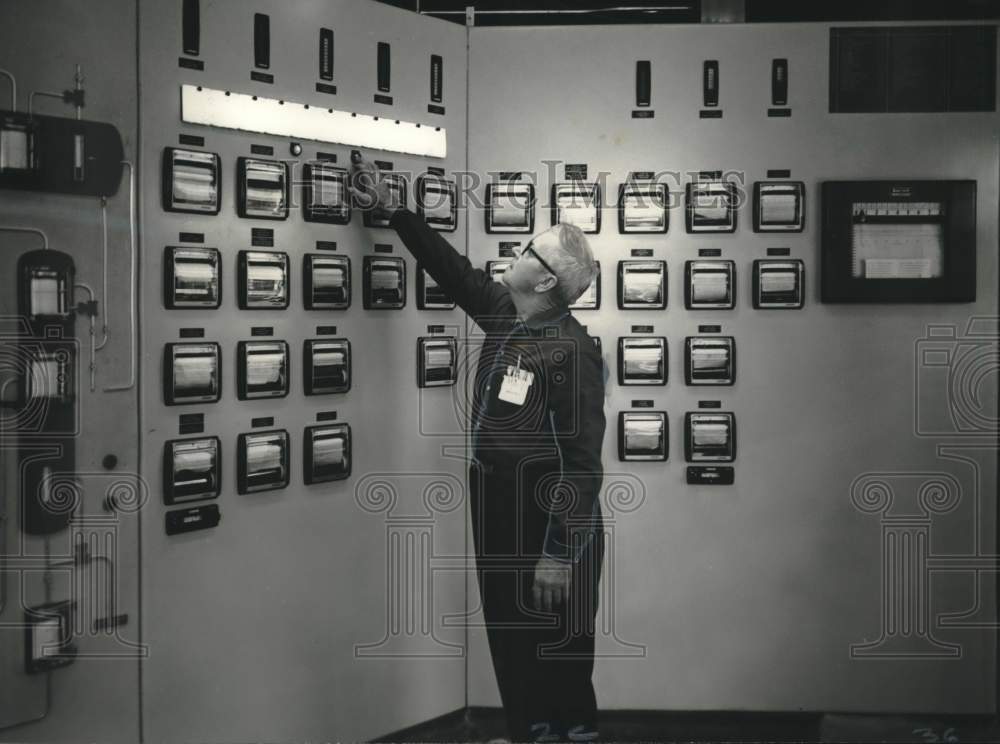 1967 Clarence George, boardman, at control panel at Murphy Corp. - Historic Images