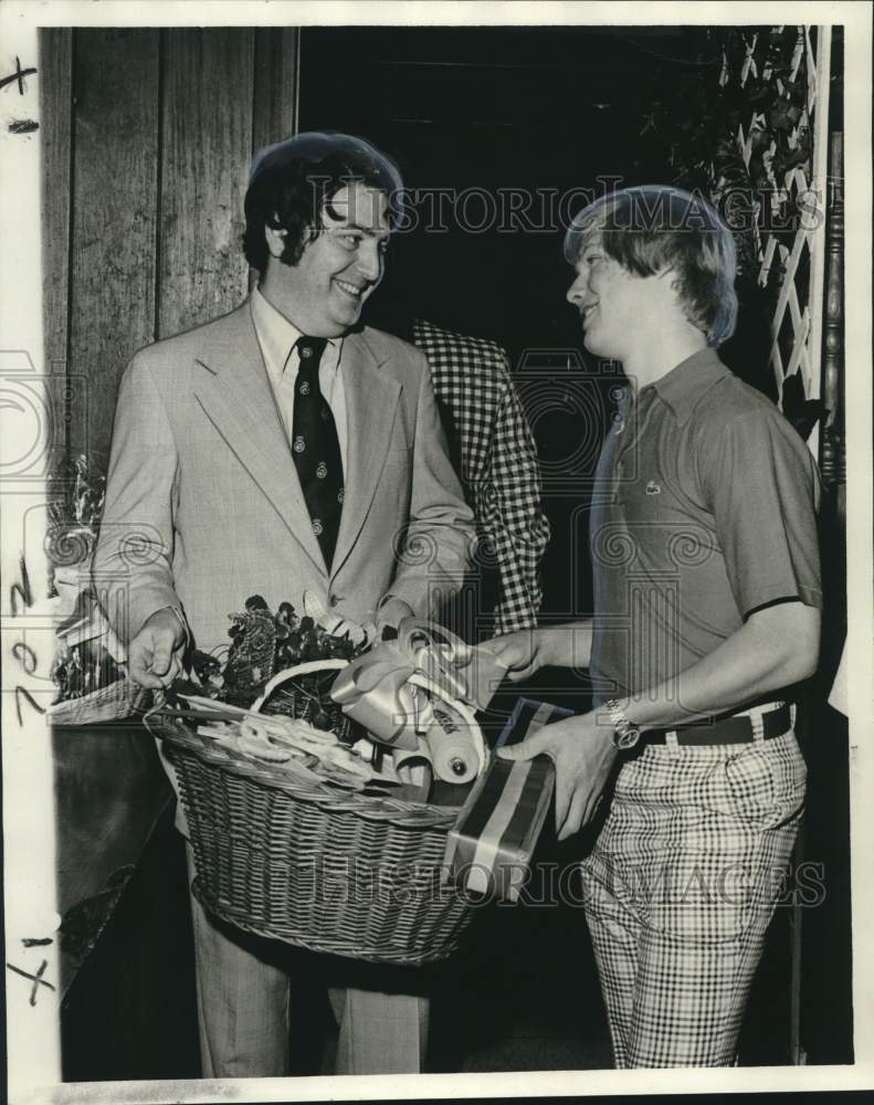 1975 David Perlis assists model Rickey Scott with door prizes - Historic Images