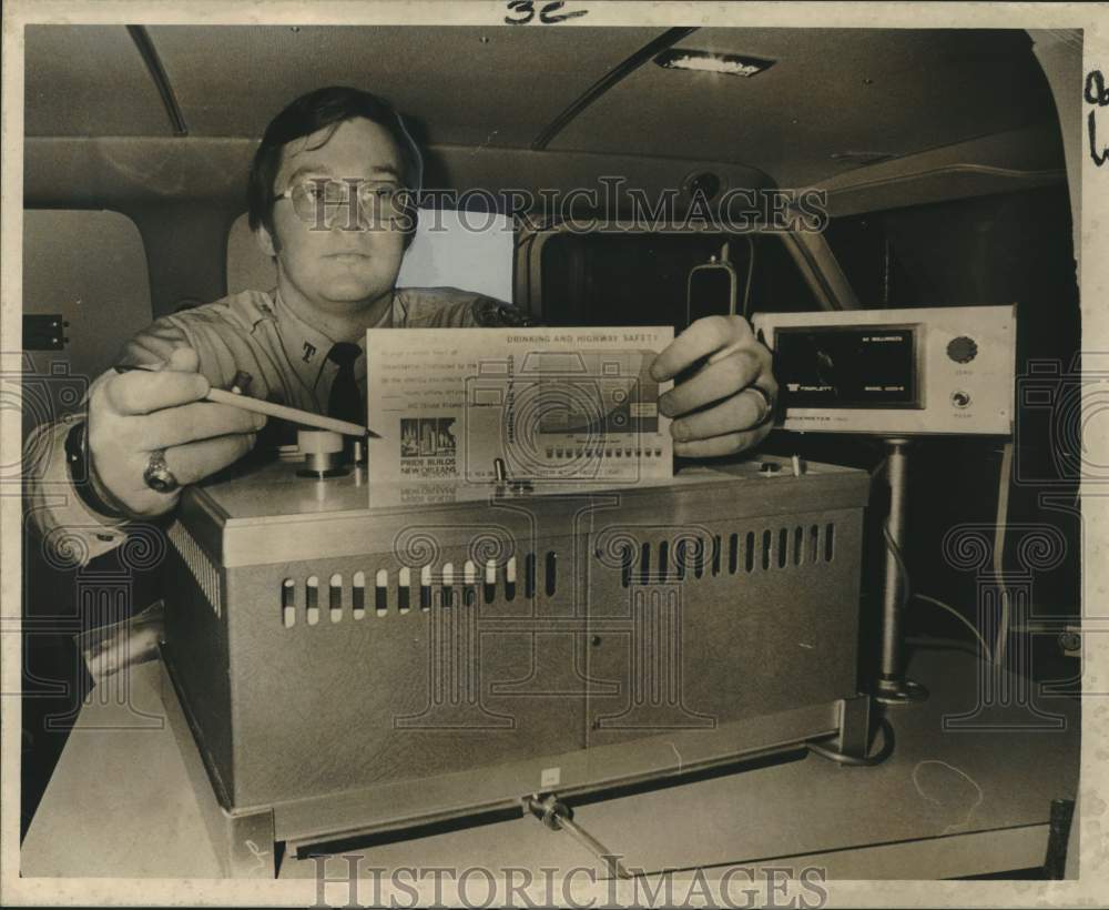 Patrolman James Hernandez displays intoximeter to test pedestrians - Historic Images