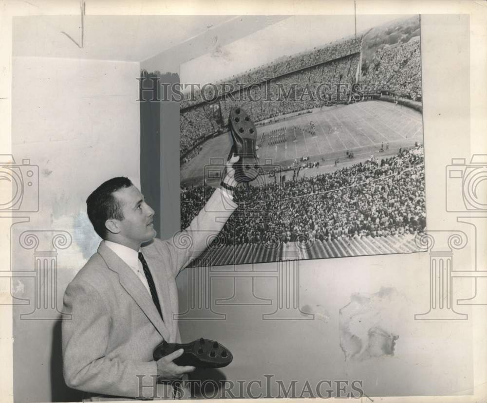 1980 Press Photo John Petitbon holds football cleat in front of stadium picture- Historic Images