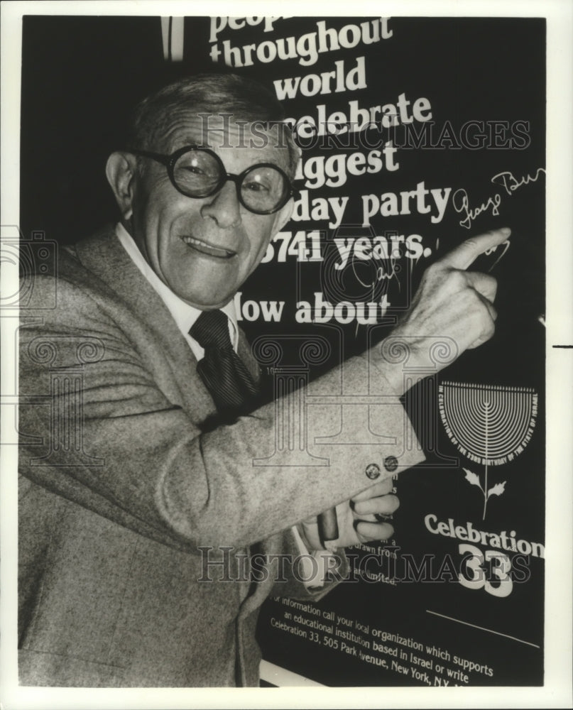 1981 George Burns signs poster outside Hollywood sound stage. - Historic Images