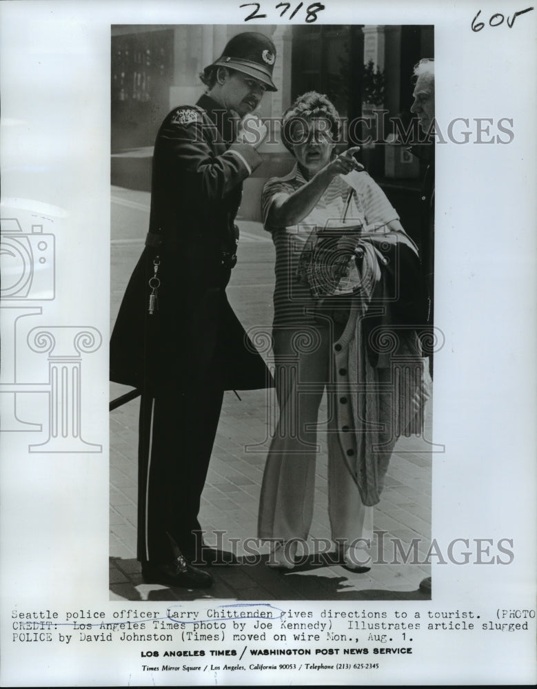 1977 Police officer Larry Chittenden gives directions to a tourist. - Historic Images