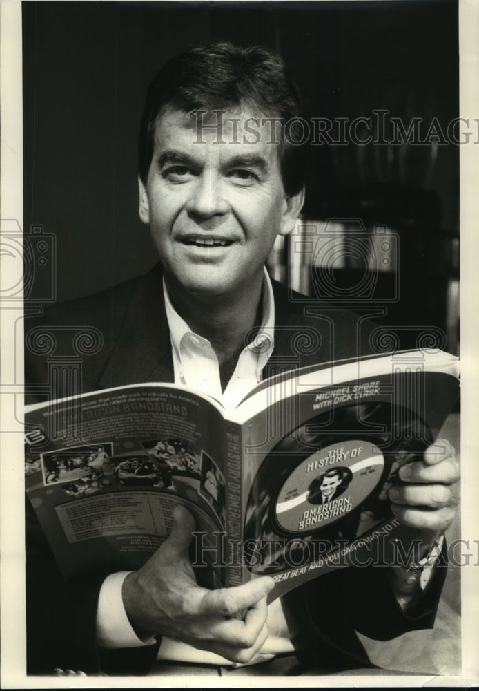 1985 Dick Clark holding American Bandstand book - Historic Images