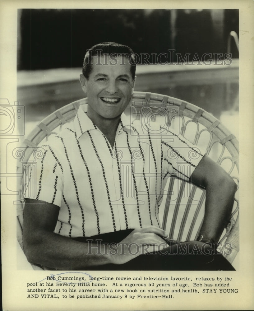 1961 Press Photo Bob Cummings, relaxes by his pool, Beverly Hills - Historic Images