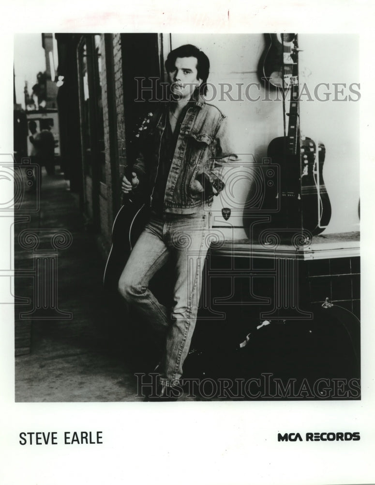 1986 Press Photo Steve Earle, musician with his guitars - nop26574 - Historic Images