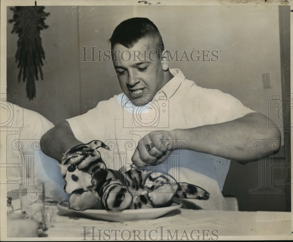 1965 Sugar Bowl, Gary Bugenhagen of Syracuse cuts into a toy tiger - Historic Images