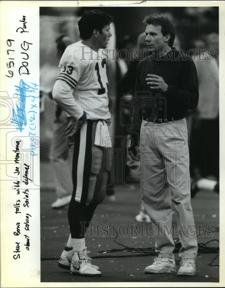 New Orleans Saints- Steve Bond talks with Joe Montana. - Historic Images