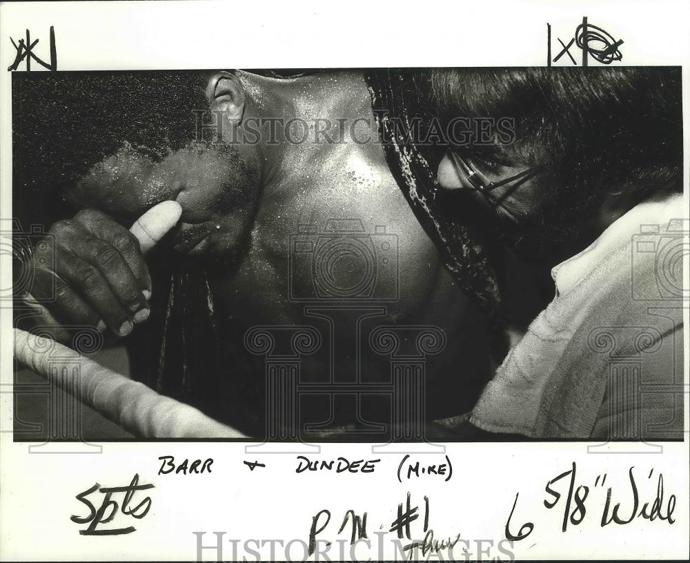 1981 Press Photo Mike Dundee applies the ice as Ernie Barr bends over in pain - Historic Images